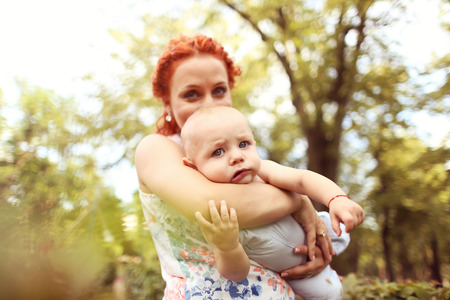 Mother holding her son in the parkの写真素材