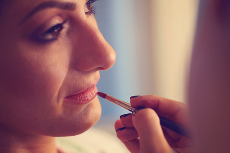 Hands of make up artist applying lipstick on brideの写真素材