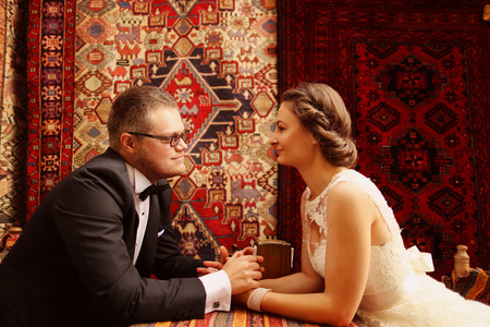 Bride and groom sitting on a tableの写真素材
