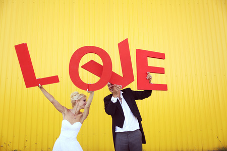 Bride and groom holding big LOVE lettersの写真素材
