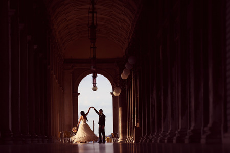 Bride and groom dancing in a tunnelの写真素材