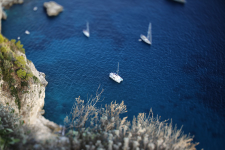Italian seascape with rocks and shipsの写真素材