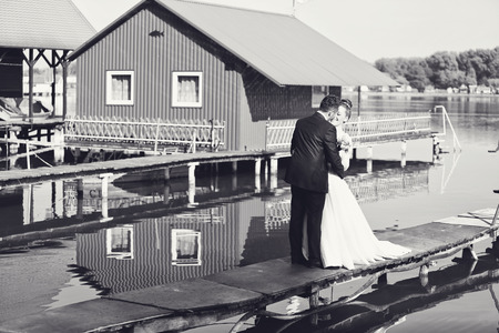 Black and white photo of bride and groom near lakeの写真素材