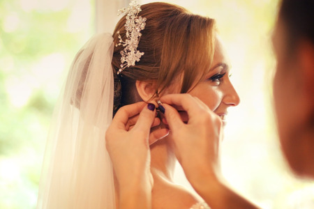 Hands helping the bride with earringsの写真素材