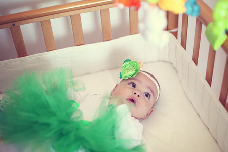 Cute baby girl on her bedの写真素材