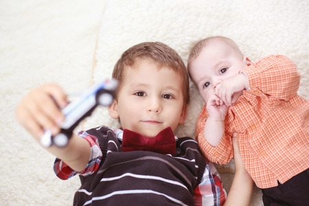 Brothers playing with a carの写真素材