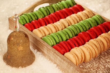 Red and green macaroons on wooden plate