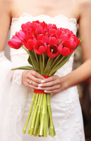 Hands holding red tulips wedding bouquetの写真素材