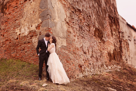 Bride and groom against a bricked wallの写真素材