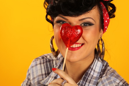 attractive brunette with a heart shaped lollypopの写真素材