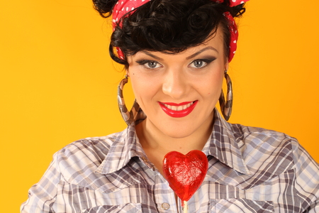 portrait of a brunette with heart shaped lollypopの写真素材