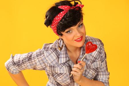 portrait of a brunette with heart shaped lollypopの写真素材