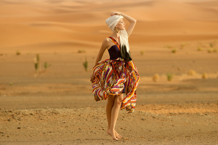 Portrait of a beauty woman in a dress in the hot desertの写真素材