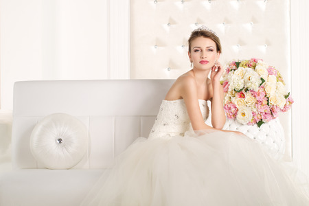 Gorgeous bride with white dress with flowers bouquetの写真素材