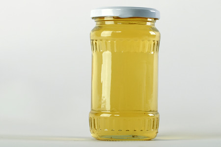 Honey jar. Honey tidbit in glass jar and honeycombs wax.の写真素材