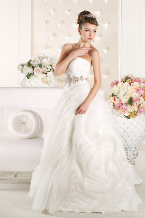 Gorgeous bride with white dress with flowers bouquetの写真素材