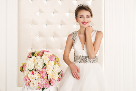 Gorgeous bride with white dress with flowers bouquetの写真素材