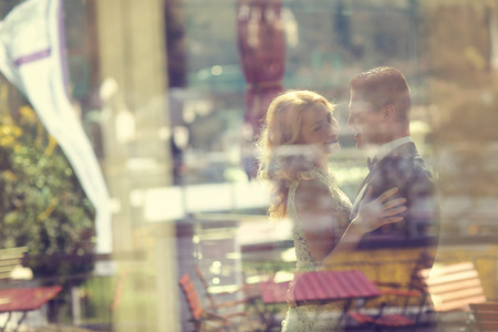 Bride and groom beeing seen through a windowの写真素材