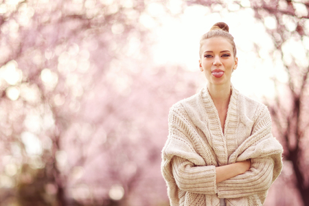 Beautiful women in spring surrounded by blossomed treesの写真素材