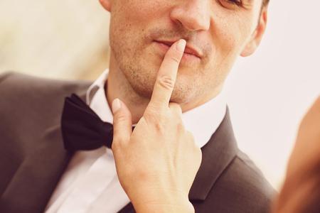 Bride making shush sign with groomの写真素材