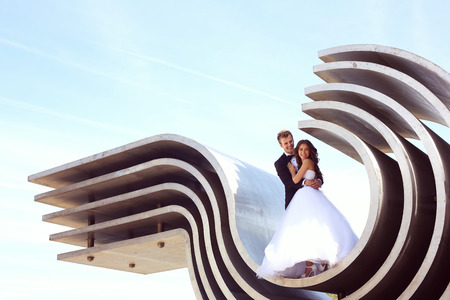 Beautiful bridal couple embracing near architectureの写真素材