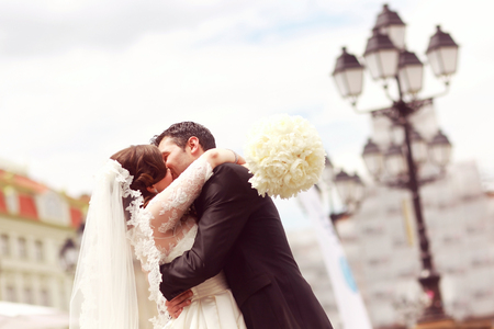 Beautiful bride and groom embracing in cityの写真素材