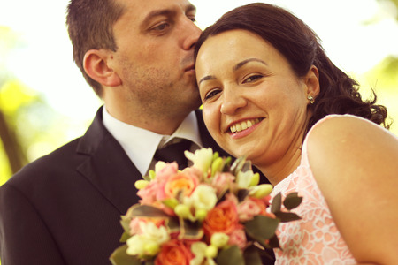 Joyful bridal couple embracing in the parkの写真素材