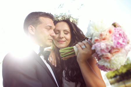 Beautiful bride and groom with bouquet on wedding dayの写真素材