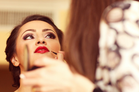 Beautiful bride getting professional make up before weddingの写真素材