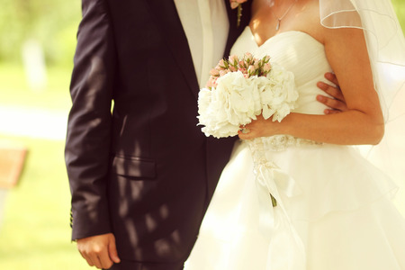 Beautiful bride and groom with bouquet on wedding dayの写真素材