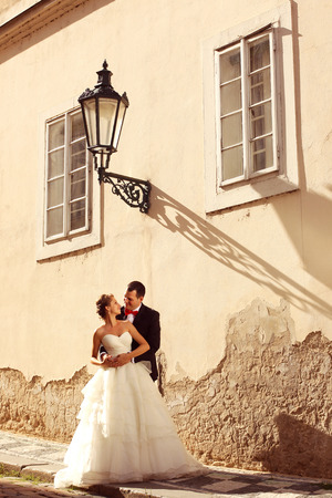 Beautiful bride and groom embracing in old city centerの写真素材