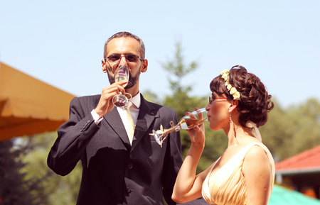 Beautiful bride and groom having champagne on wedding dayの写真素材