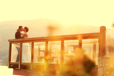 Beautiful bride and groom embracing near a lakeの写真素材