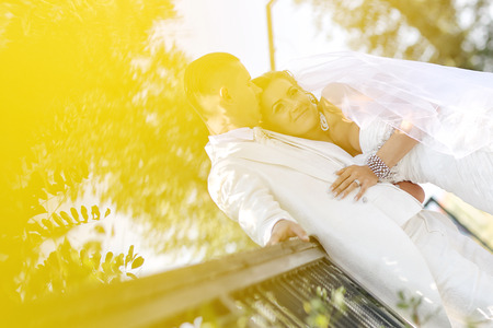 Beautiful bride and groom celebrating their wedding day in the parkの写真素材