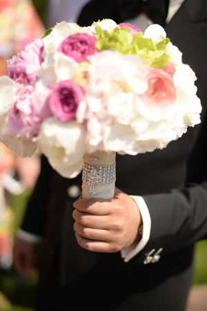 Groom with beautiful flower bouquet for the brideの写真素材