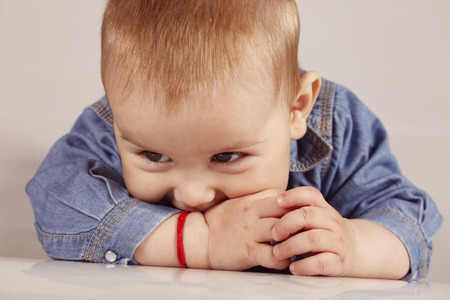 Cute little boy in denim smiling on isolated backgroundの写真素材