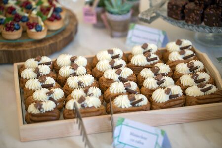 Delicious wedding reception candy bar dessert table full with cakes and sweets and a candles
