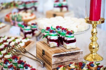 Delicious wedding reception candy bar dessert table full with cakes and sweets and a candlesのeditorial素材