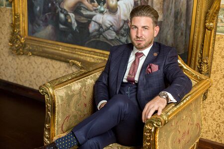 Handsome man posing on armchair in luxury hotel roomのeditorial素材