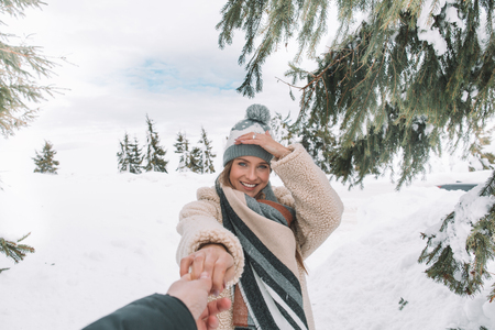 Young Romantic Couple Walking In Snow Forest Outdoor caucasian Woman Hold Man Handの写真素材