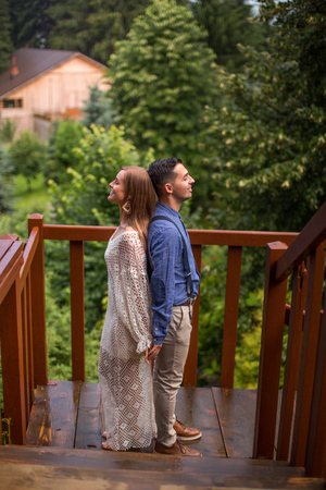 Beautiful wedding couple posing on wooden structure in natureの写真素材