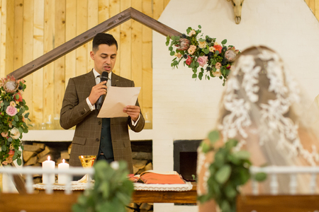 Handsome groom write a letter in front of his brideの写真素材