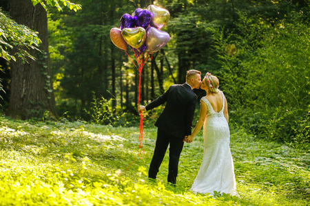 Beautiful Wedding couple posing in nature with baloonsの写真素材