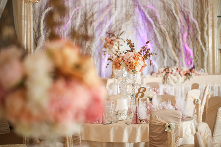 Beautiful white round table at the restaurant. Wedding reception day. Champagne and floral compositionの写真素材