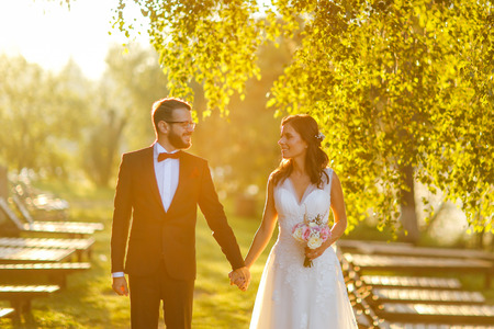 Beautiful wedding couple posing outdoor at sunsetの写真素材