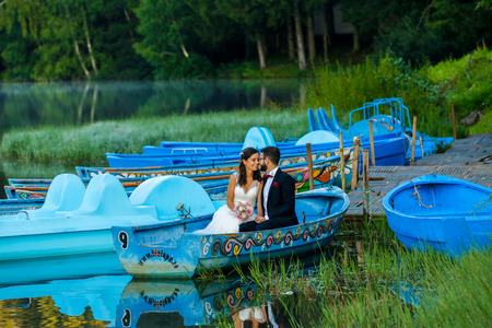 beautiful young wedding couple,bride with her groom just married on small boatの写真素材