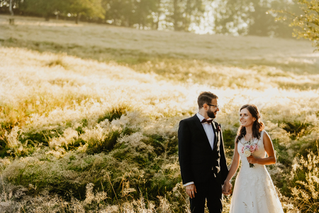 Beautiful wedding couple, bride and groom posing on wheat fieldの写真素材