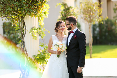 Beautiful wedding couple posing outdoor near luxury structureの写真素材