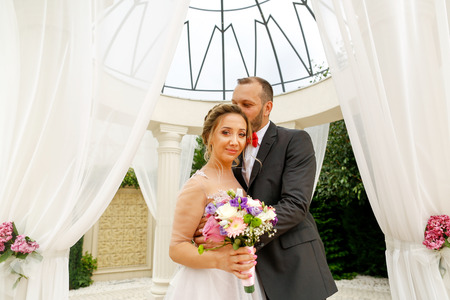 Beautiful wedding couple posing near pavilionの写真素材