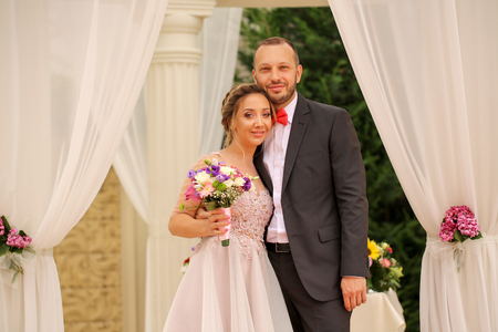 Beautiful wedding couple posing near pavilionの写真素材
